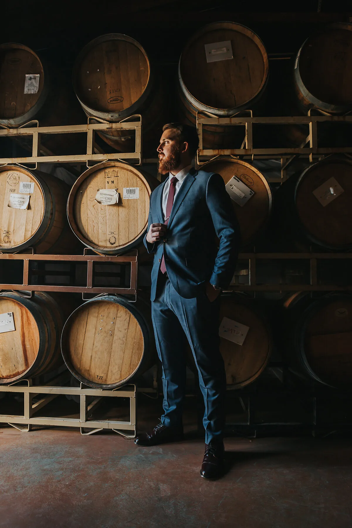 Logan Sullivan, Founder of Grand Funding LLC, in a wine cellar wearing a tailored blue suit